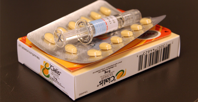 A flu vaccine sits on top of packages of erectile dysfunction drugs