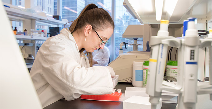 Kayla Marsh, a Research Technician, wiorks at a bench in the OICR-PM Translational Genomics Laboratory.