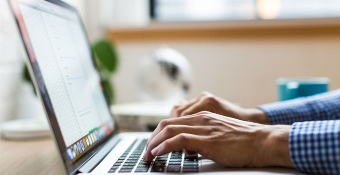 Close up of a person using a laptop.